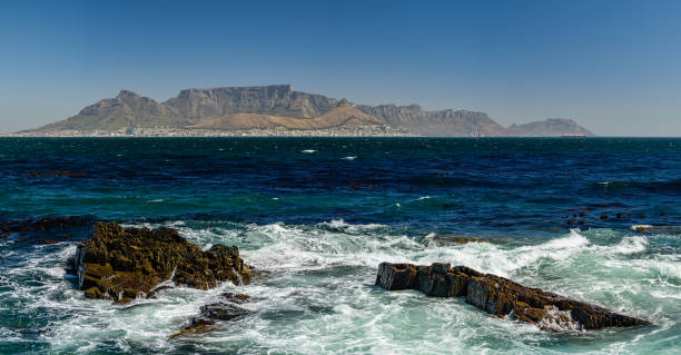 istock Table mountain in Cape Town from distant the Robben Island. Rocky cliffs in the foreground. 1363867500