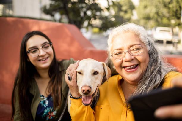 istock Mother and daughter take selfie with dog 1363868425