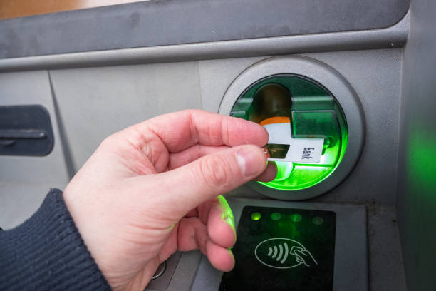 istock Man putting credit card in ATM 1363868511