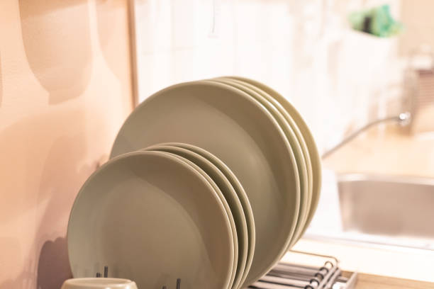 istock Stand for plates in the kitchen, new design.Shelf for tableware drying in modern kitchen. ceramic plates and cups on metal rack inside kitchen cupboard. 1363868567