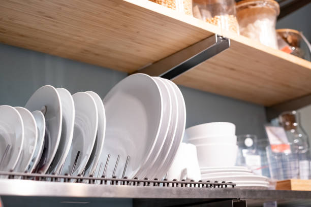 istock Stand for plates in the kitchen, new design.Shelf for tableware drying in modern kitchen. ceramic plates and cups on metal rack inside kitchen cupboard. 1363868582
