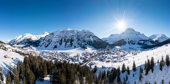 Aerial view panorama of the snow-covered village Lech and the Lech river during winter, one of the most famous ski-resorts. Vorarlberg, Austria