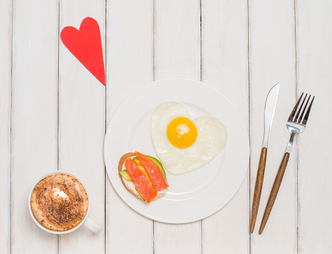 Romantic breakfast on white wooden background. Valentines day food background.