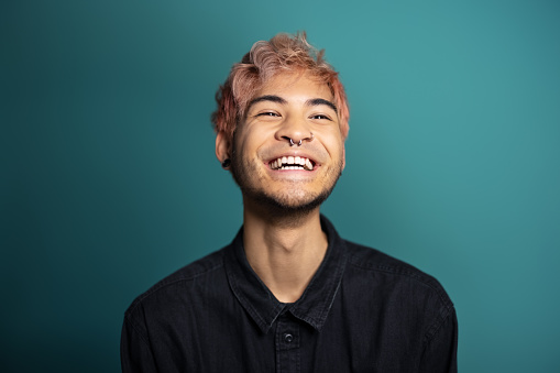 Cheerful young man smiling on blue background