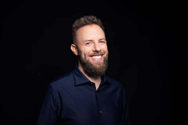 istock Portrait of a friendly young man on black background 1363870843