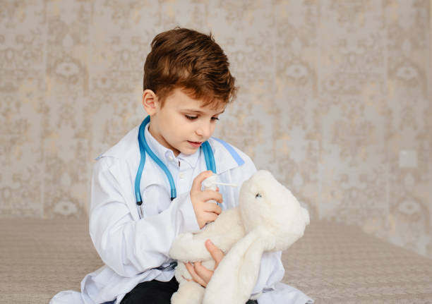 istock Little boy in white medical robe having fun 1363871019