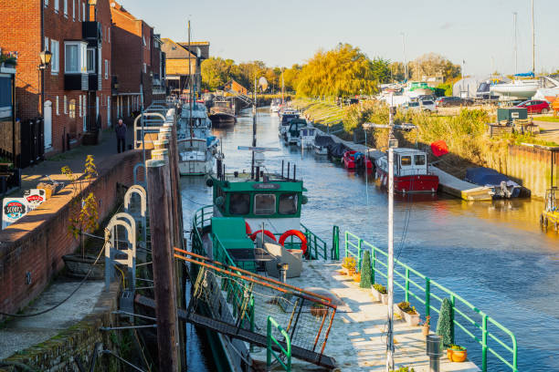 Boats moored on the river Stour by the the Barbican and Tollbridge on a sunny autumn day. Sandwich, UK - Oct 28 2021 Boats moored on the river Stour by the the Barbican and Tollbridge on a sunny autumn day. sandwich kent stock pictures, royalty-free photos & images