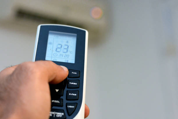 istock a human hand with its thumb pressing an air conditioner remote control to turn on the air conditioning fan and to adjust the room temperature 1363875507