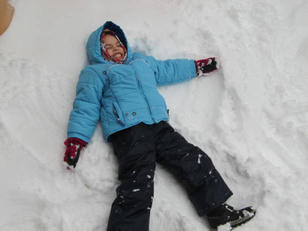 istock Little Girl Making Snow Angel 1363876522