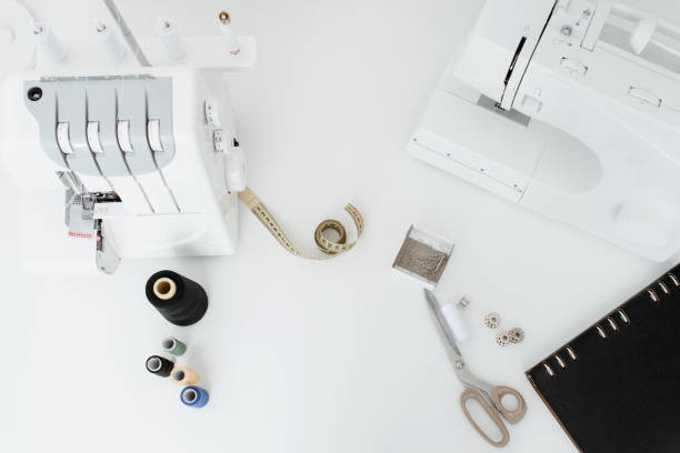 istock Close up sewing and overlock machines, spool of thread, scissors, centimeter ribbon 1363876640