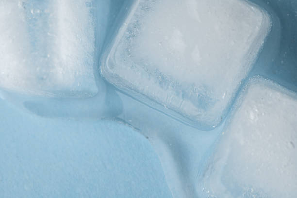 istock Ice cubes and water drops on blue background. 1363878143