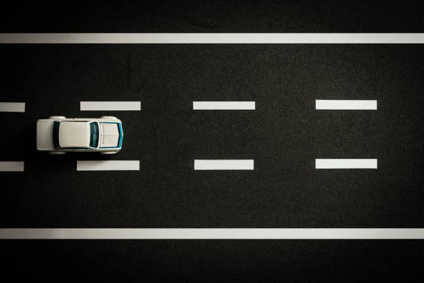 istock Top view of tiny model car speeding on black highway. 1363880044