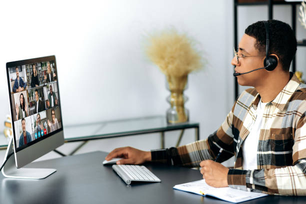 istock Online consultation, video communication. Side view of a hispanic man with a headset communicating with business partners, discussing a project, conducts a consultation, multiethnic people on a screen 1363885052