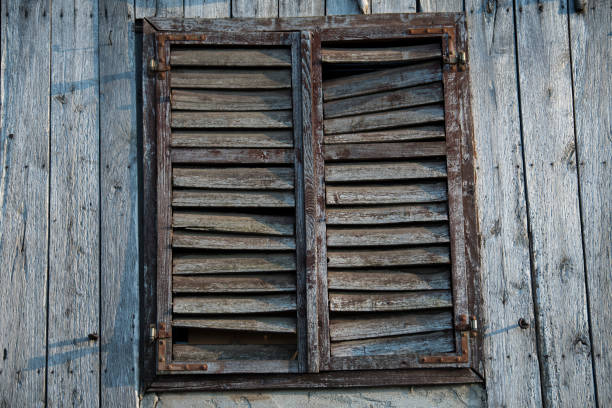 Sunja, Croatia, 05,04,2021: Rustic style aged window in wooden village rural home wall.
