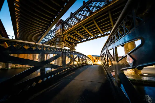 Dark and gloomy industrial atmosphere under the historical rail bridges in Manchester