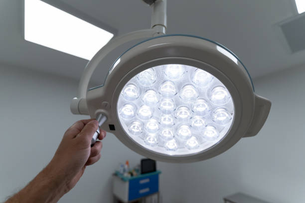 istock Doctor's hand holding a lit surgical light in a hospital operating room 1363889955