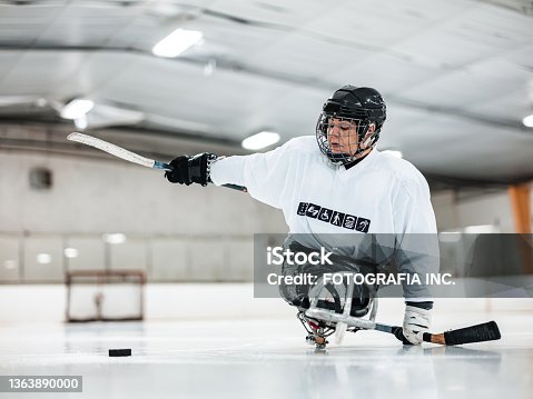 istock Mature Disabled Latin woman playing sledge hockey 1363890000