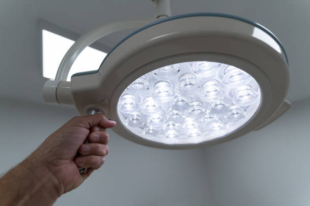 istock Doctor's hand holding a lit surgical light in a hospital operating room 1363890608