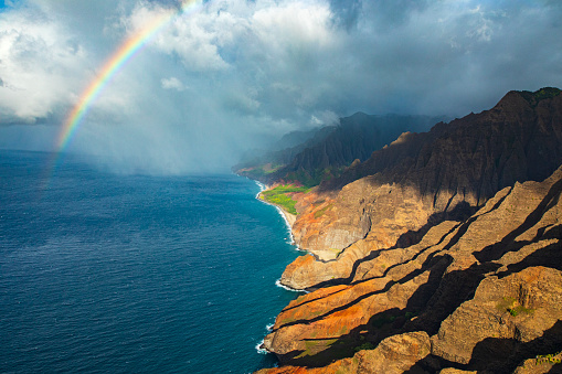High angle view of rainbow shining out of ocean across hawaiian coastline