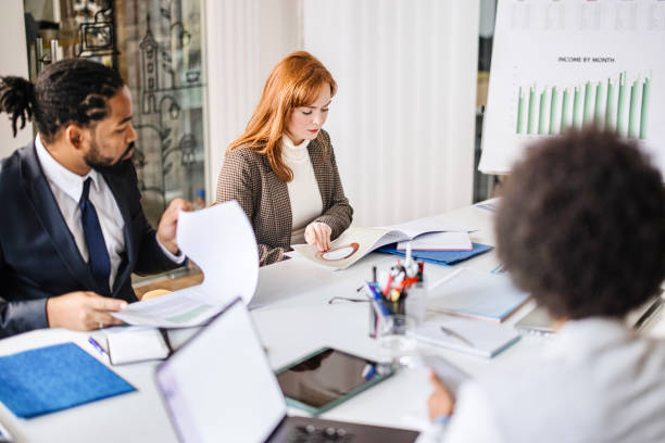 Diverse group of businesspeople discussing during a meeting around a table in an office boardroom Team of corporate professionals having discussion in a meeting in conference room. lawyer stock pictures, royalty-free photos & images