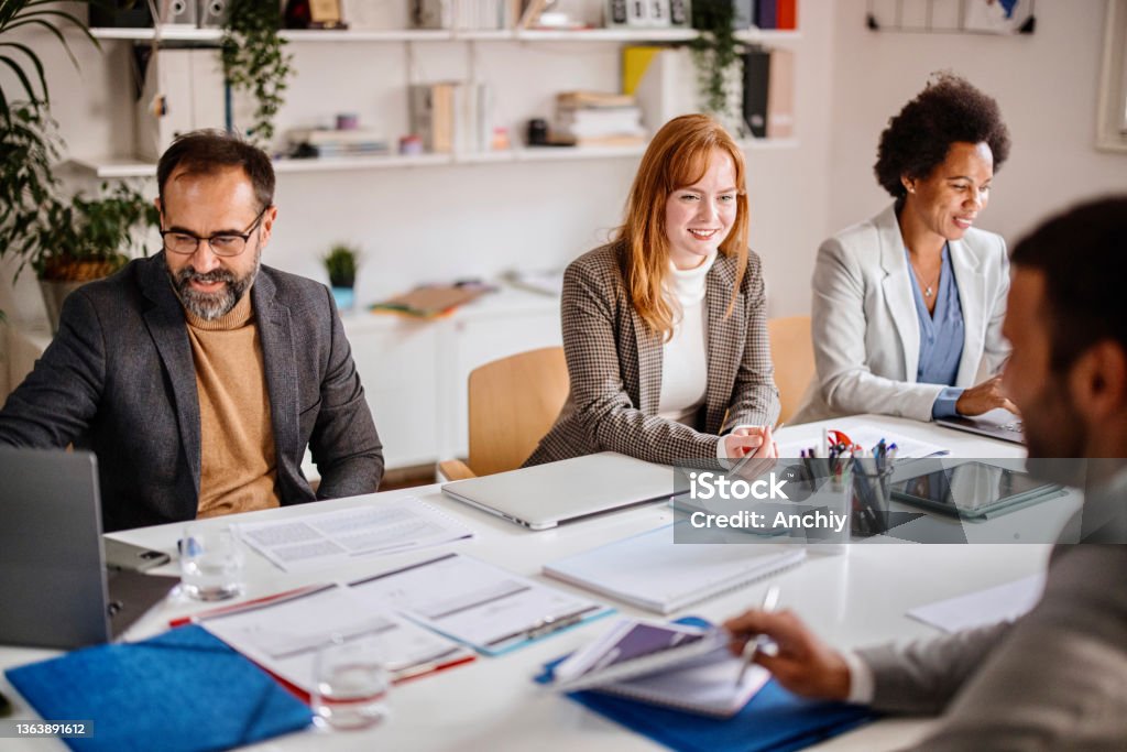 Businesswomen Listening to Associate During boardroom meeting Team of corporate professionals having discussion in a meeting in conference room. Legal System Stock Photo