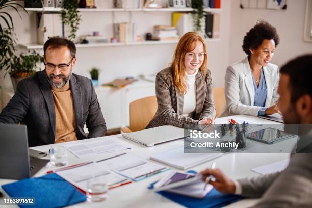 Businesswomen Listening To Associate During Boardroom Meeting Stock Photo - Download Image Now