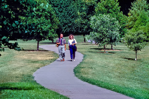 Springfield, Missouri, USA August 8, 2006: A male and female post graduate students walk on a curved sidewalk .