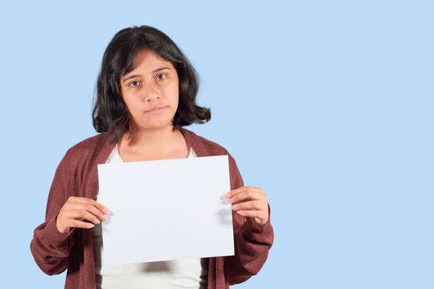 istock Serious latin young woman showing blank advertisement. Isolated 1363892684