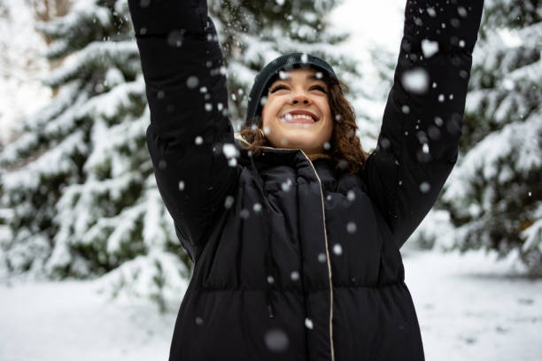 istock Happy young woman playing with snow 1363893391