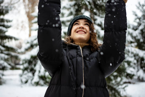 istock Happy young woman playing with snow 1363893407