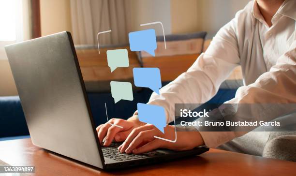 Chatting Concept Message Bubbles Floating Of A Laptop Simulating A Conversation Stock Photo - Download Image Now