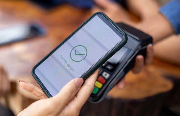 istock Close-up on a customer making a contactless payment with her phone 1363895241