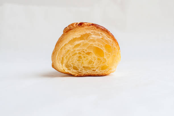 Cut of croissant on a parchment paper. Ready to eat puff pastry baking.