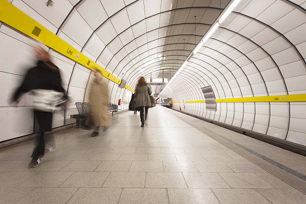 motion blurred commuters against rund down subway platform stock photo