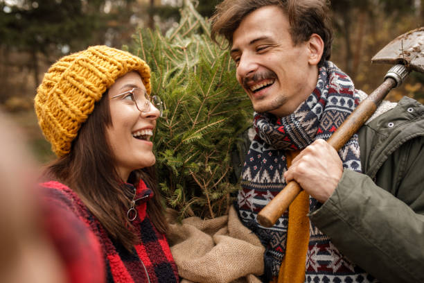 istock Young couple taking a selfie with their new Christmas tree 1363903987
