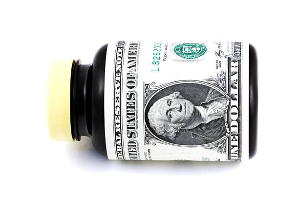 Pill bottles wrapped in one dollar bills stock photo