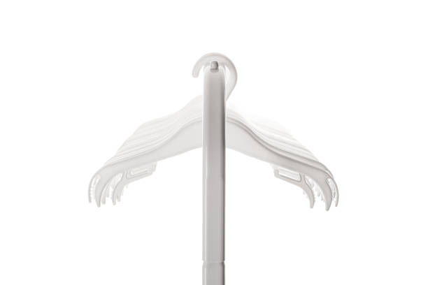 White plastic hangers for clothes hanging on rod from clothing rack. Isolated on white background.. White plastic hangers for clothes hanging on rod from clothing rack. Isolated on white background. clothes hanger rod stock pictures, royalty-free photos & images
