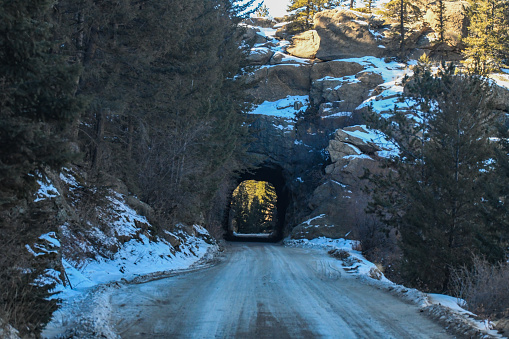 Narrow dirt road and tunnels through Rocky Mountain canyon at 11 Mile Canyon in central Colorado. Nearby cities and towns are Colorado Springs, Woodland Park and Cripple Creek, Colorado in western United States of America (USA).