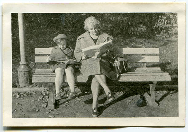 Vintage photo of mother and daughter reading in park Fifties park bench photos stock pictures, royalty-free photos & images