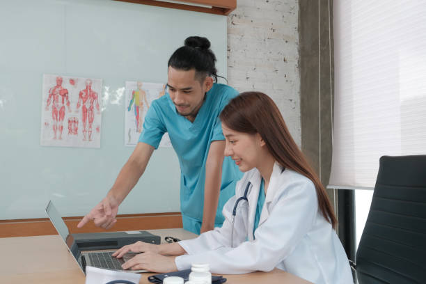 istock Two uniformed young doctors work in medical clinic office. 1363927151