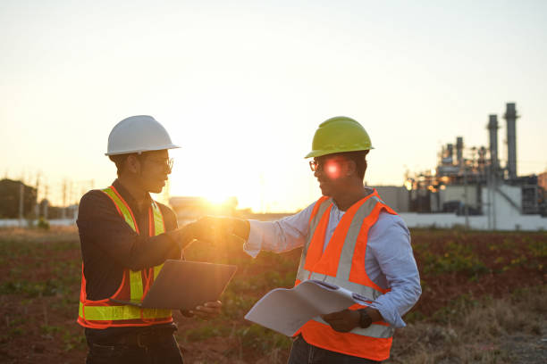 istock Architect and engineer looking at the construction site and a blueprint both looking very satisfied and handshaking 1363927296