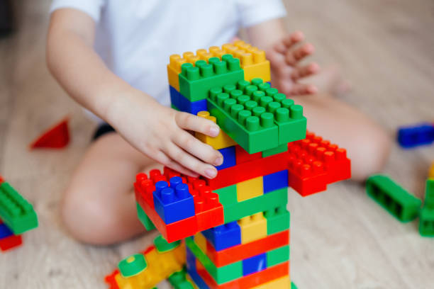 istock Boy in a white T-shirt playing with lots of colorful plastic blocks constructor 1363934614