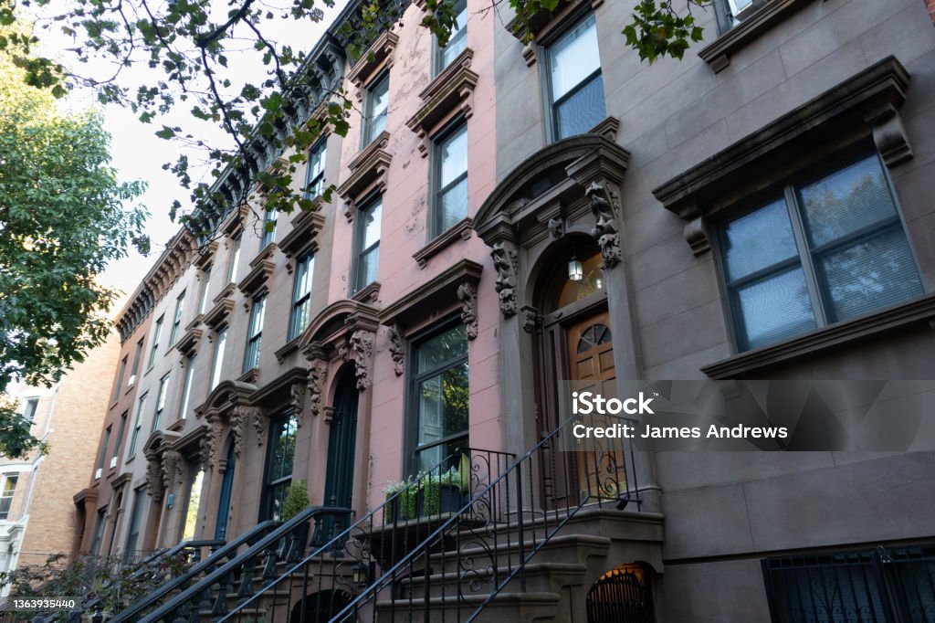 Row of Colorful Old Brownstone Homes and Residential Buildings in Carroll Gardens Brooklyn of New York City A row of colorful old brownstone homes and residential buildings with staircases in Carroll Gardens Brooklyn of New York City Brooklyn - New York Stock Photo