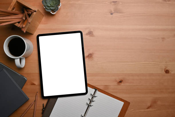 istock Digital tablet, notebook, coffee cup and pencil holder on wooden table. 1363939991