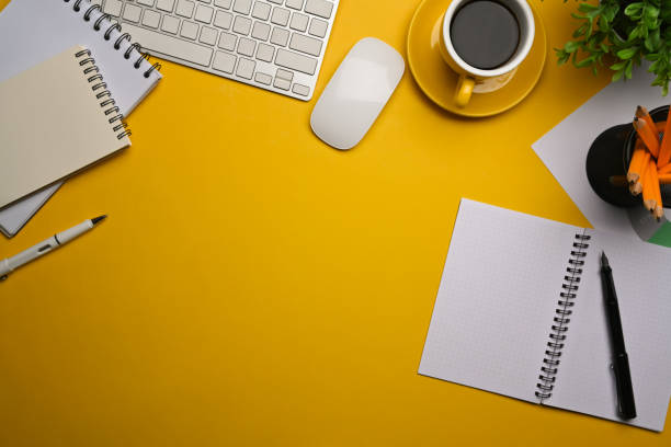 istock Stylish workspace with notebook, coffee cup and houseplant on yellow background. 1363940058
