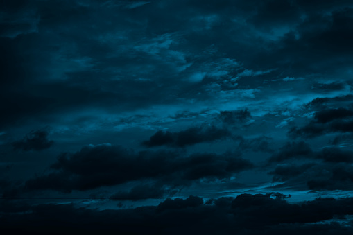 Dramatic sky with clouds. Black blue green night sky.