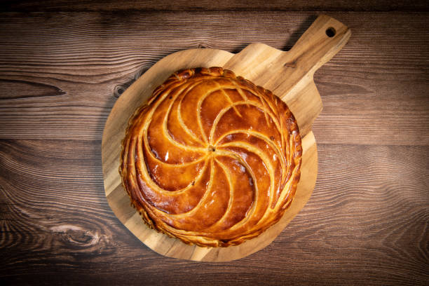 galette des rois on wooden table, traditional epiphany cake in france - galeta stok fotoğraflar ve resimler