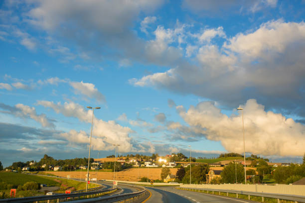 istock Road with trees, cars and cloudy sky in Norway 1363950902