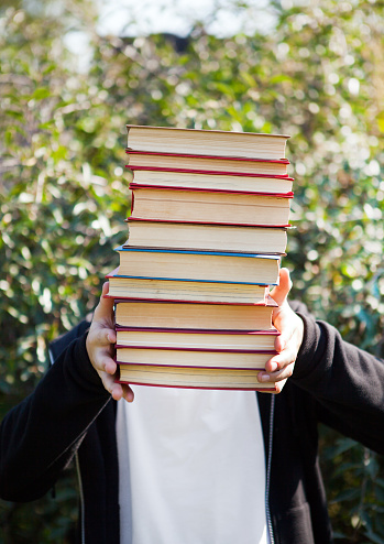 Person with a Books by the Nature Background