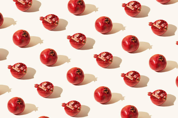 istock Creative pattern made of fresh pomegranates on pastel background with sunlit. Minimal style. Top view. Flat lay . 1363957140